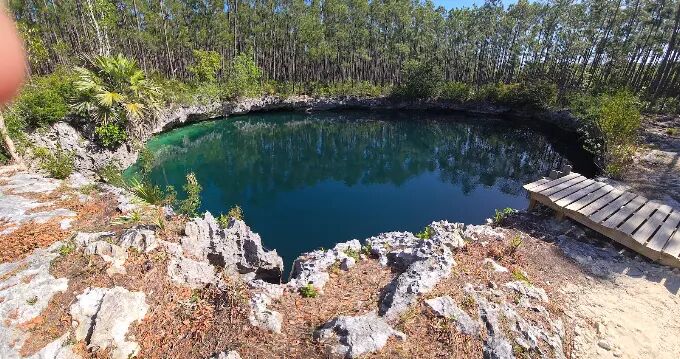 Andros blue hole with wooden platform and limestone rim